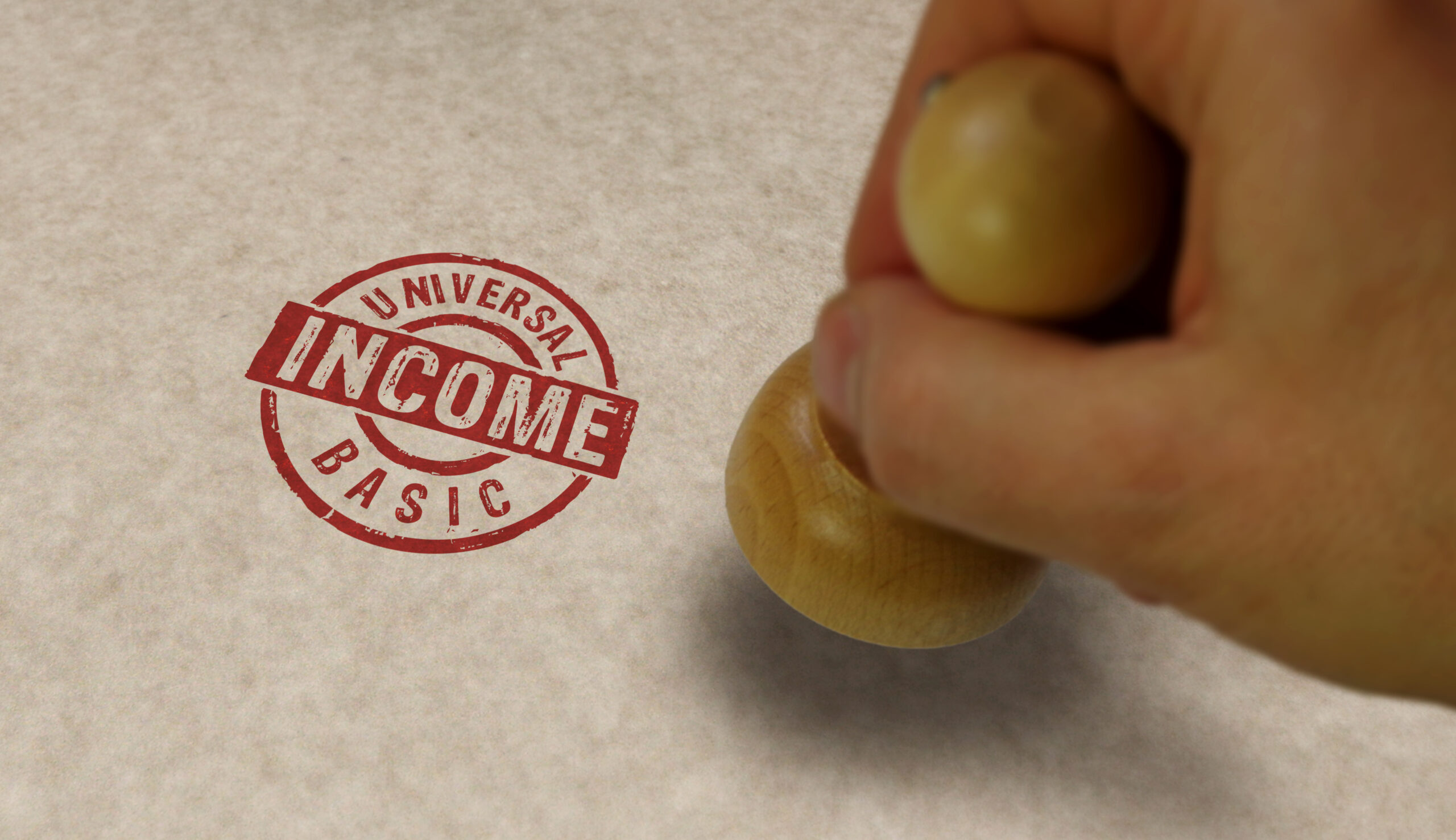 Universal Basic Income stamp and stamping hand.